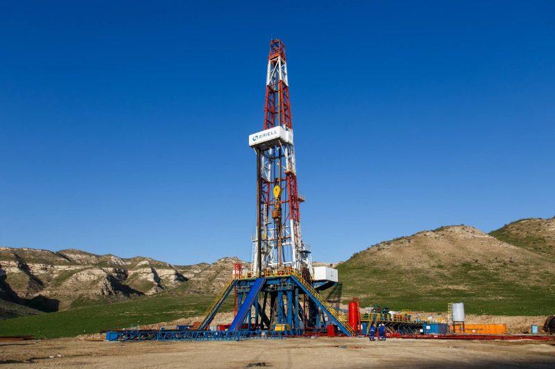 oil drilling rig in front of hills